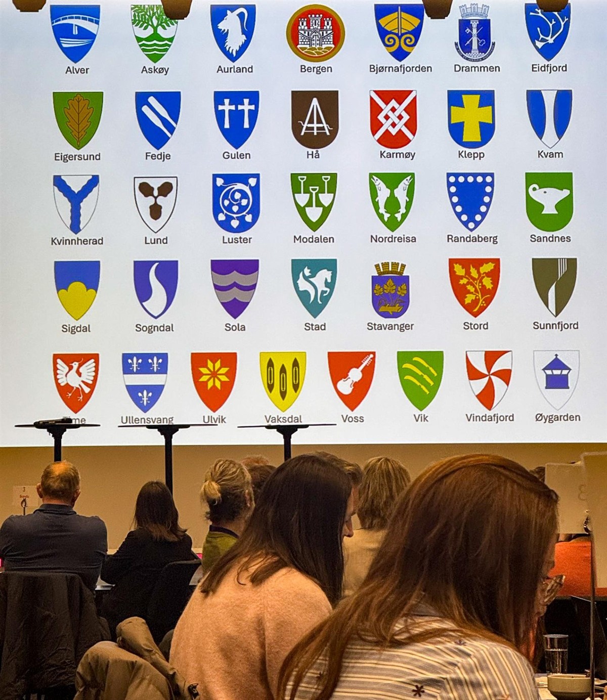 Alle kommunane med kommunevåpen lista på skjermen på scena - Klikk for stort bilete